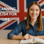 Jovem sorridente olhando para a câmera enquanto estuda inglês com um livro aberto e a bandeira do Reino Unido ao fundo.